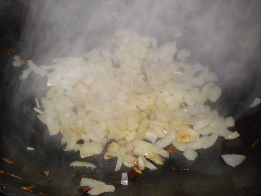 steam rising from a hot wok, browning some yellow onions